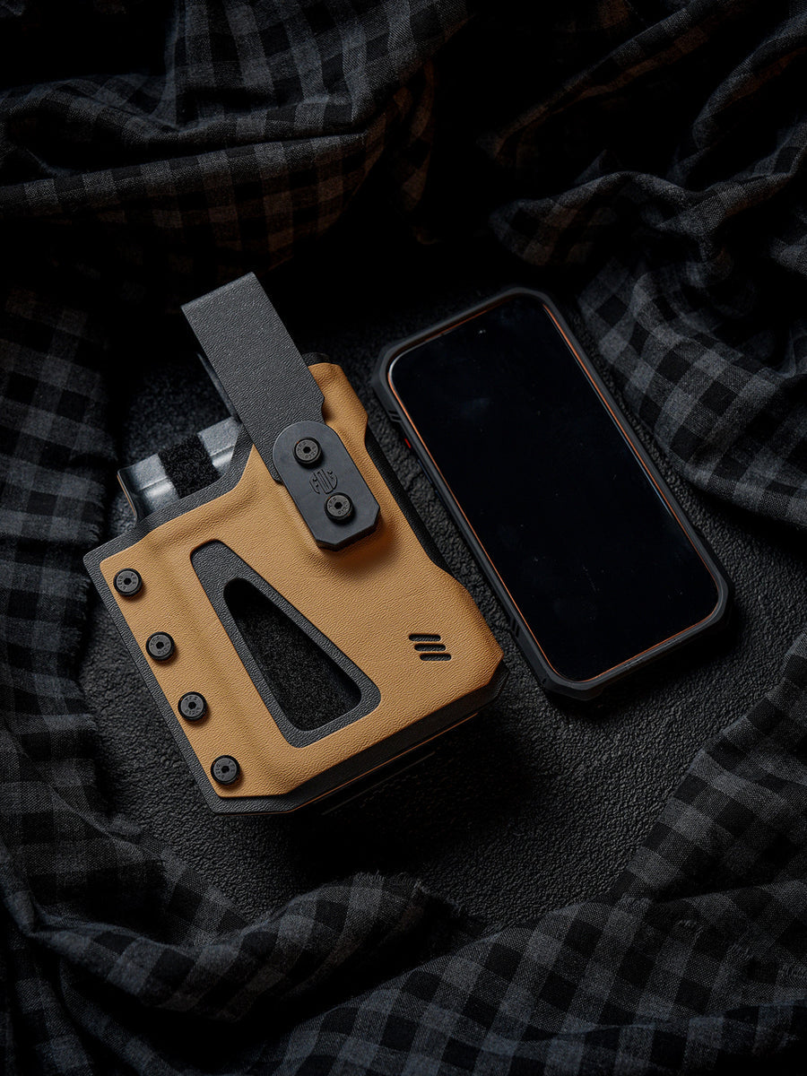 Flat lay of the tan Single Skeleton Window phone case placed beside a smartphone, showing the front opening and overall size comparison.