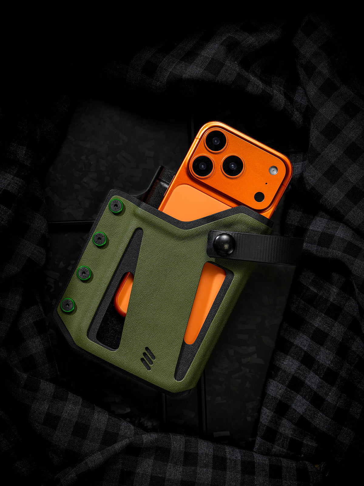 Olive green Skeleton Frame phone case shown with the retention strap opened, revealing an orange smartphone inside the holster.