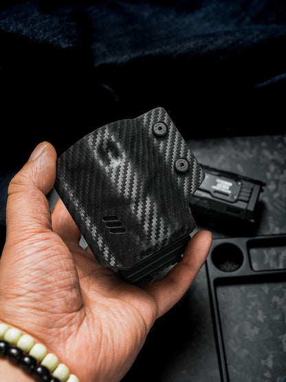 Handheld front detail of the carbon fiber texture TACTICALGEEK TG TX13 KYDEX sheath with NITECORE EDC37