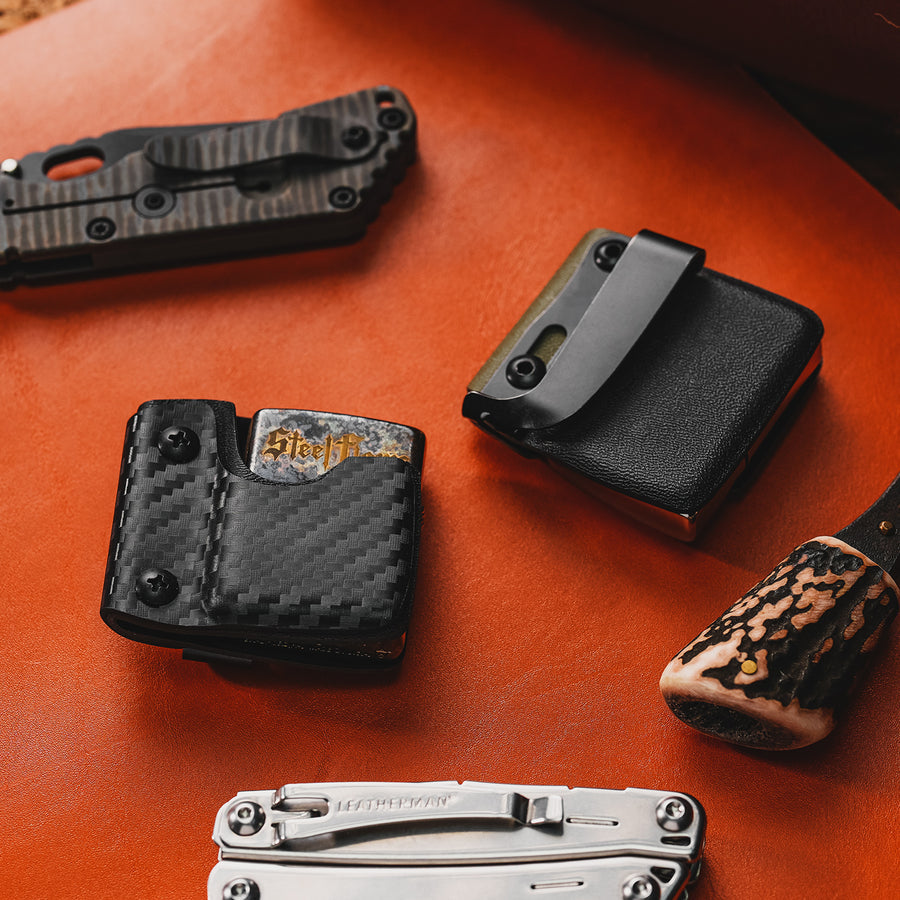 Desktop lifestyle image of the carbon fiber TX2 KYDEX EDC Zippo lighter sheath displayed with EDC gear.