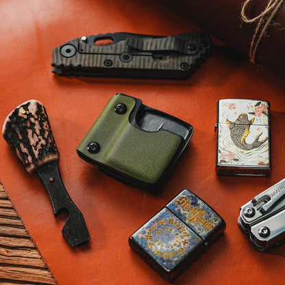 Desktop lifestyle image of the green TX2 KYDEX EDC Zippo lighter sheath displayed with EDC gear and lighters.