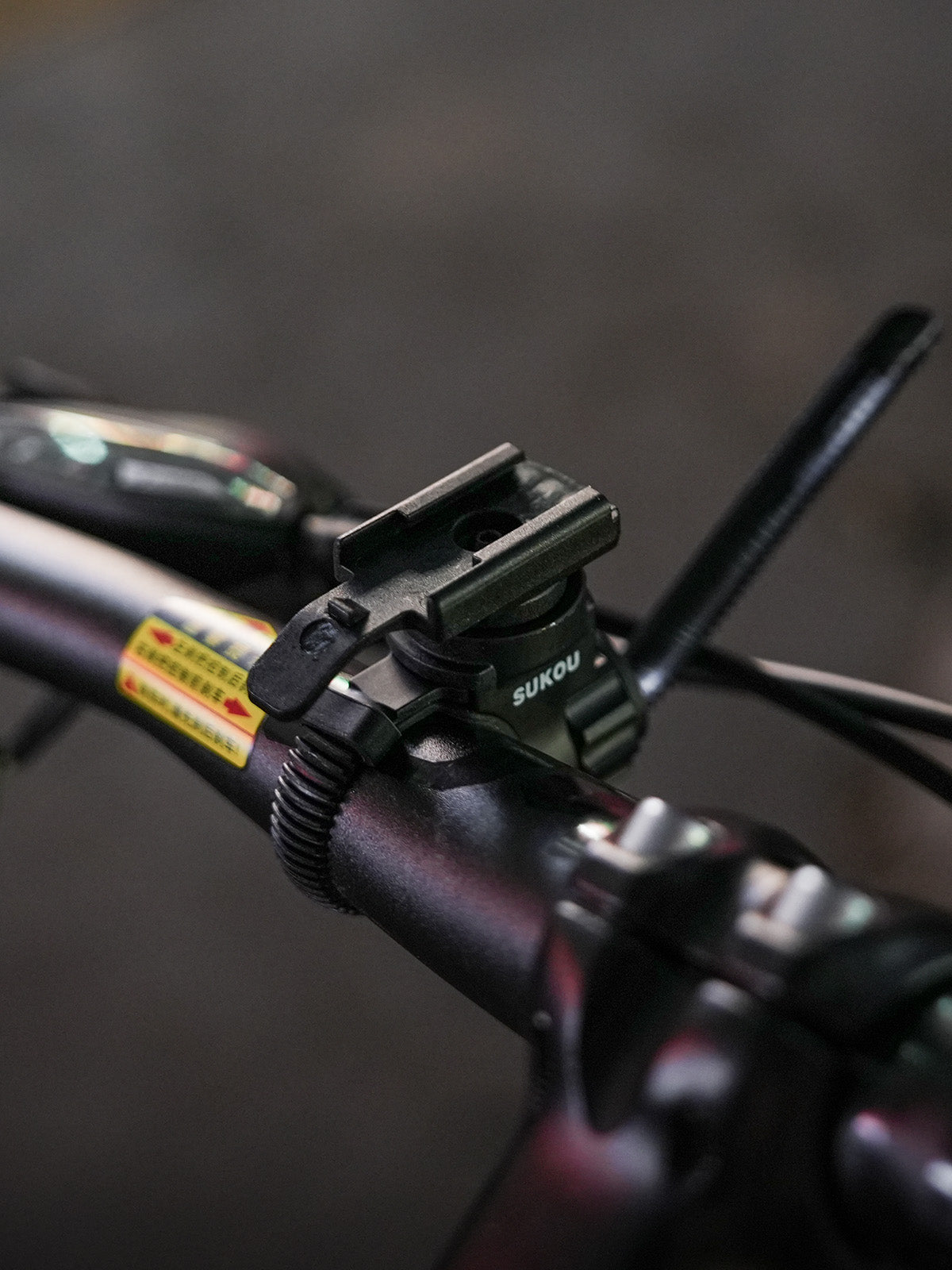 Removable adjustable bicycle clamp for the TX10 flashlight sheath for Nitecore EDC29, shown separately on a handlebar.