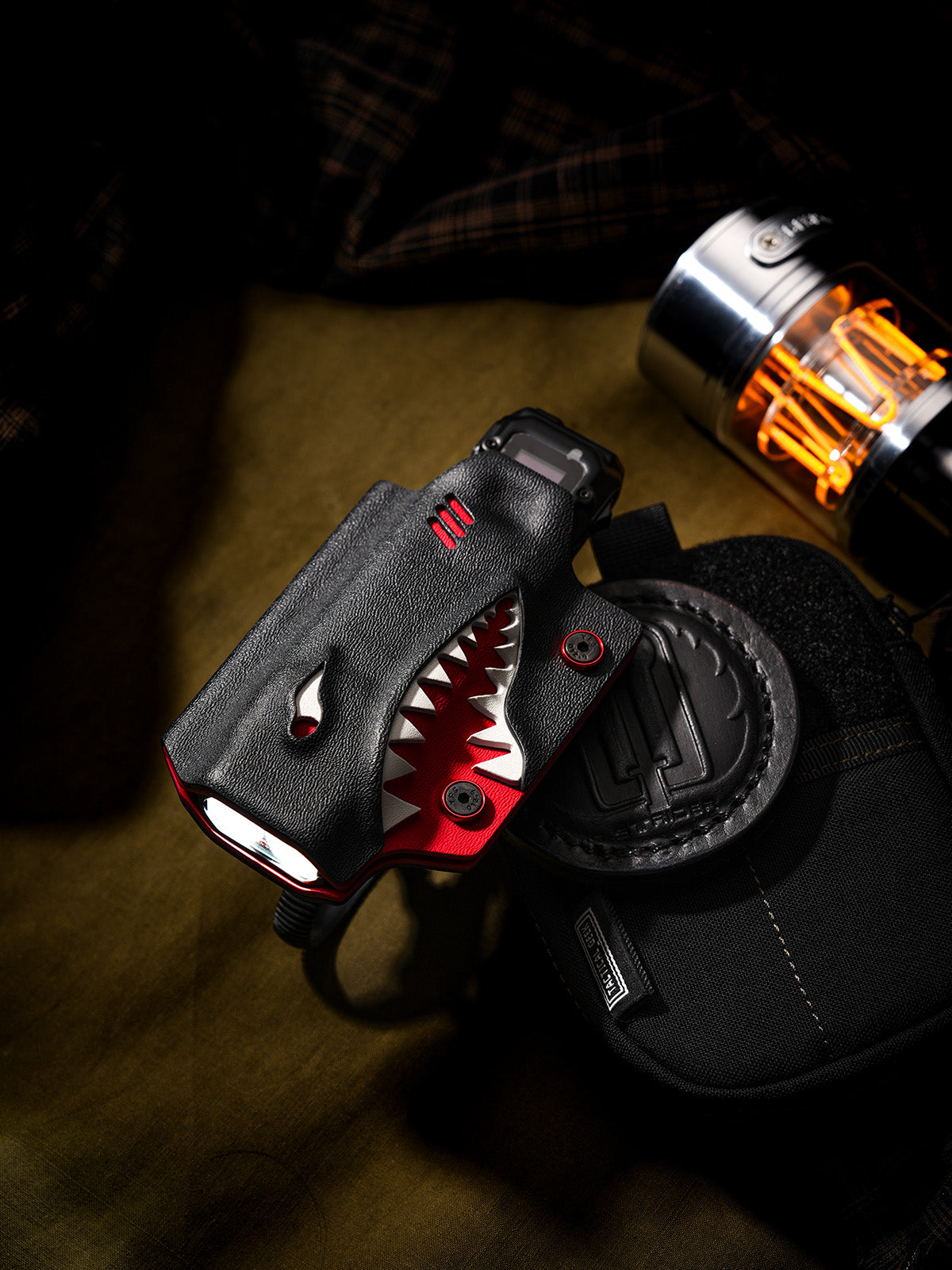 Shark-style TX10 flashlight sheath for Nitecore EDC29 with bicycle clamp, displayed on a tactical pouch.