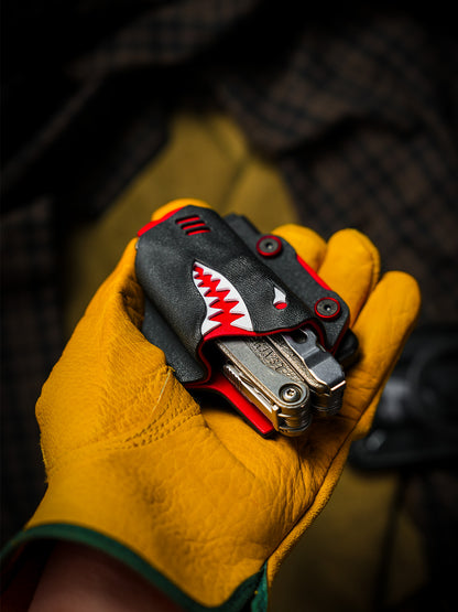 Shark-style TX15 multi-tool sheath for Leatherman Charge with belt clip, resting in a gloved palm with the tool inserted.