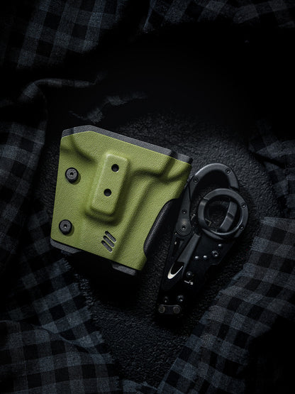 TACTICALGEEK TX18 Multi-Tool Sheath for SOG ParaShears in green colorway displayed beside the SOG ParaShears tool on a dark fabric background.