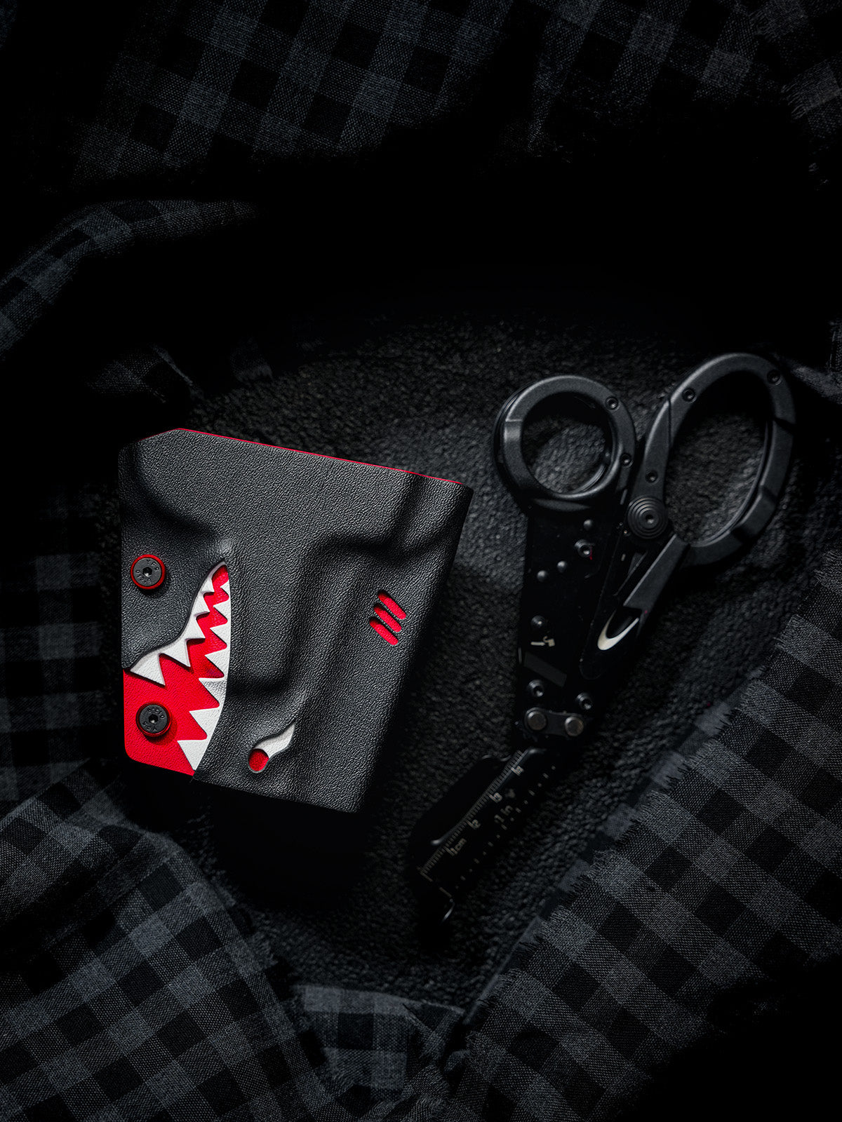 TACTICALGEEK TX18 Multi-Tool Sheath for SOG ParaShears in shark colorway with the tool partially extended, displayed on dark fabric.