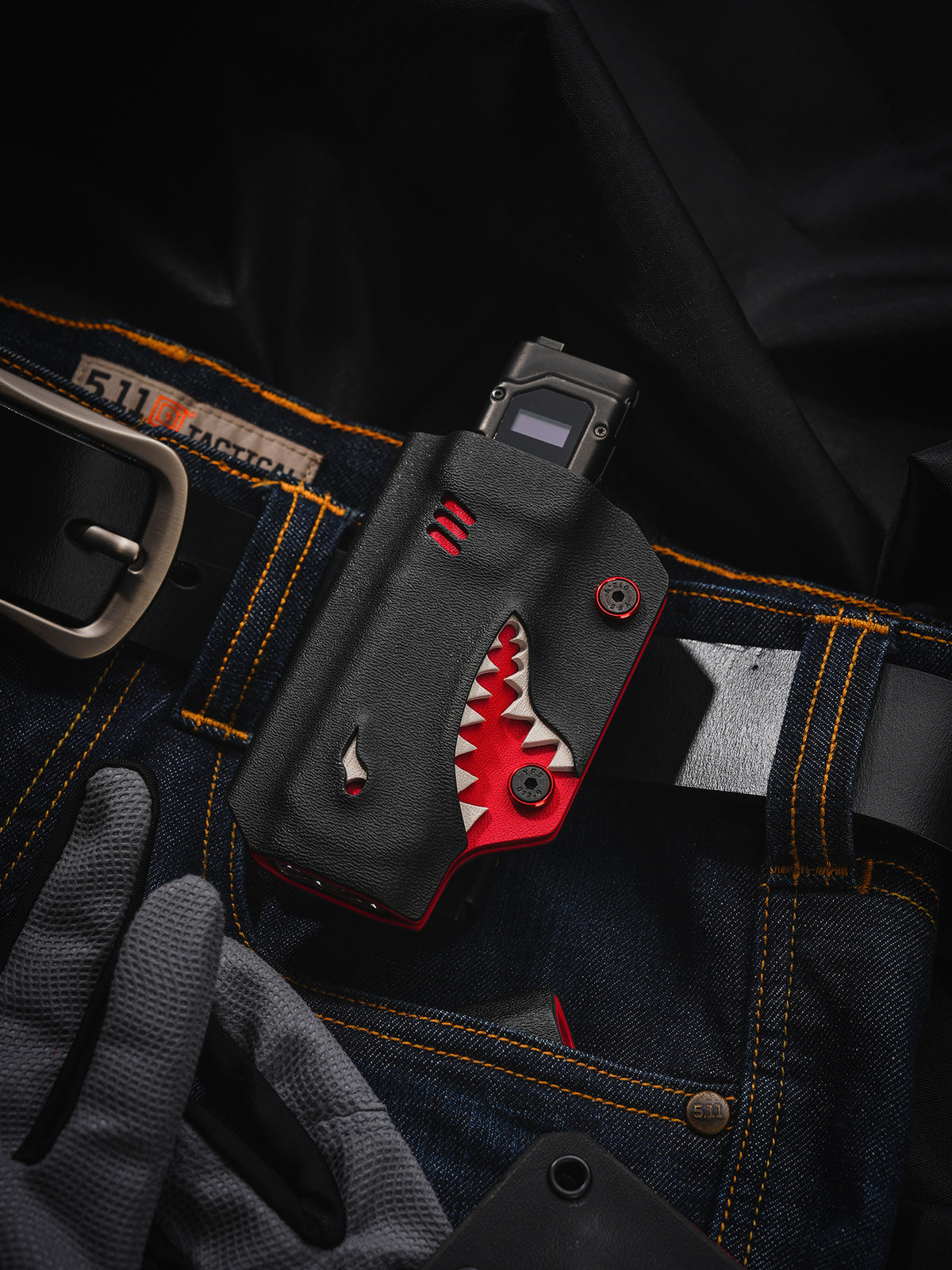 TACTICALGEEK TX9 flashlight sheath for Nitecore EDC27 shown in a belt carry flat lay with jeans and gloves.