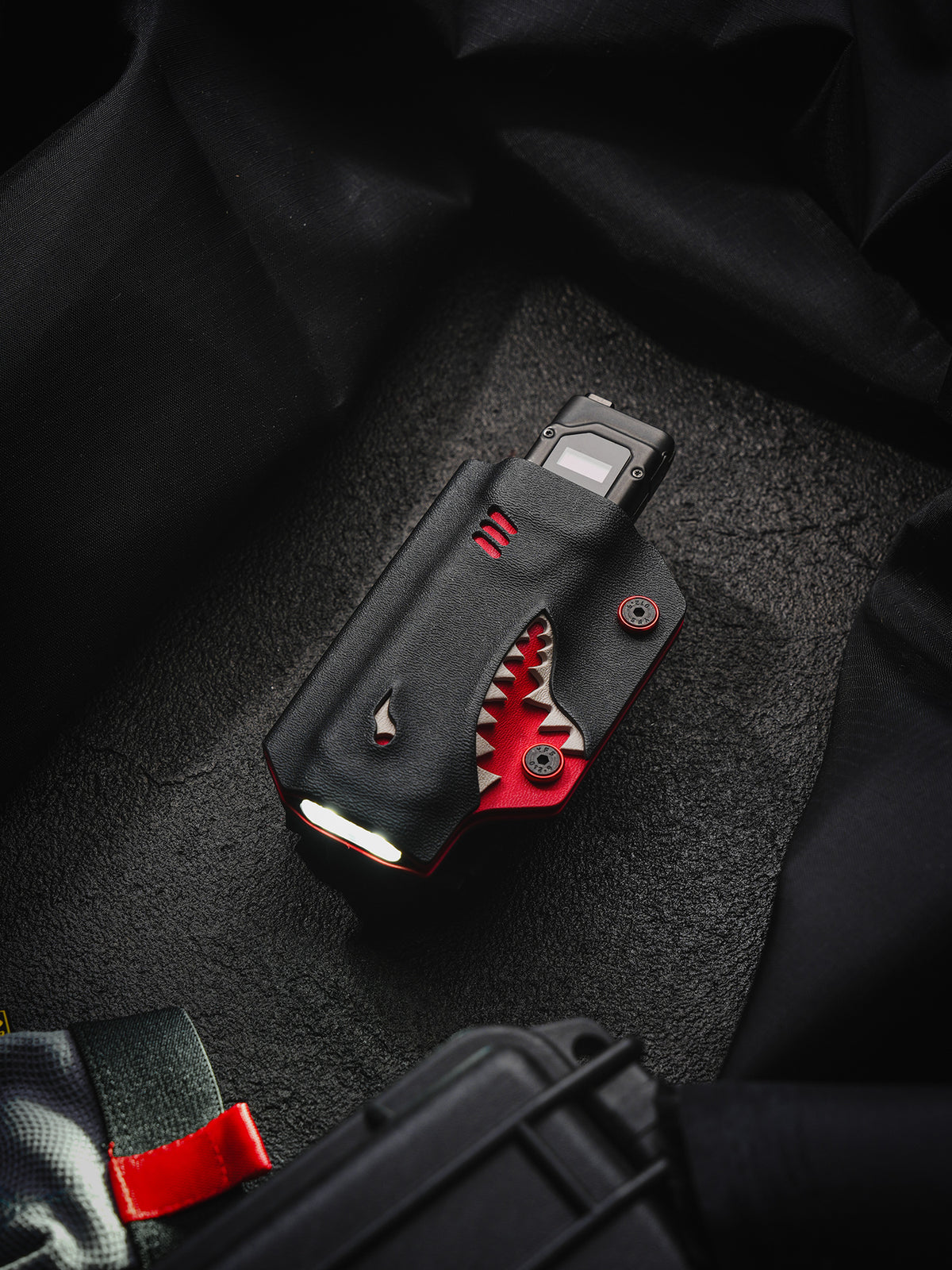 TACTICALGEEK TX9 flashlight sheath for Nitecore EDC27 with illuminated front view on a dark textured surface.