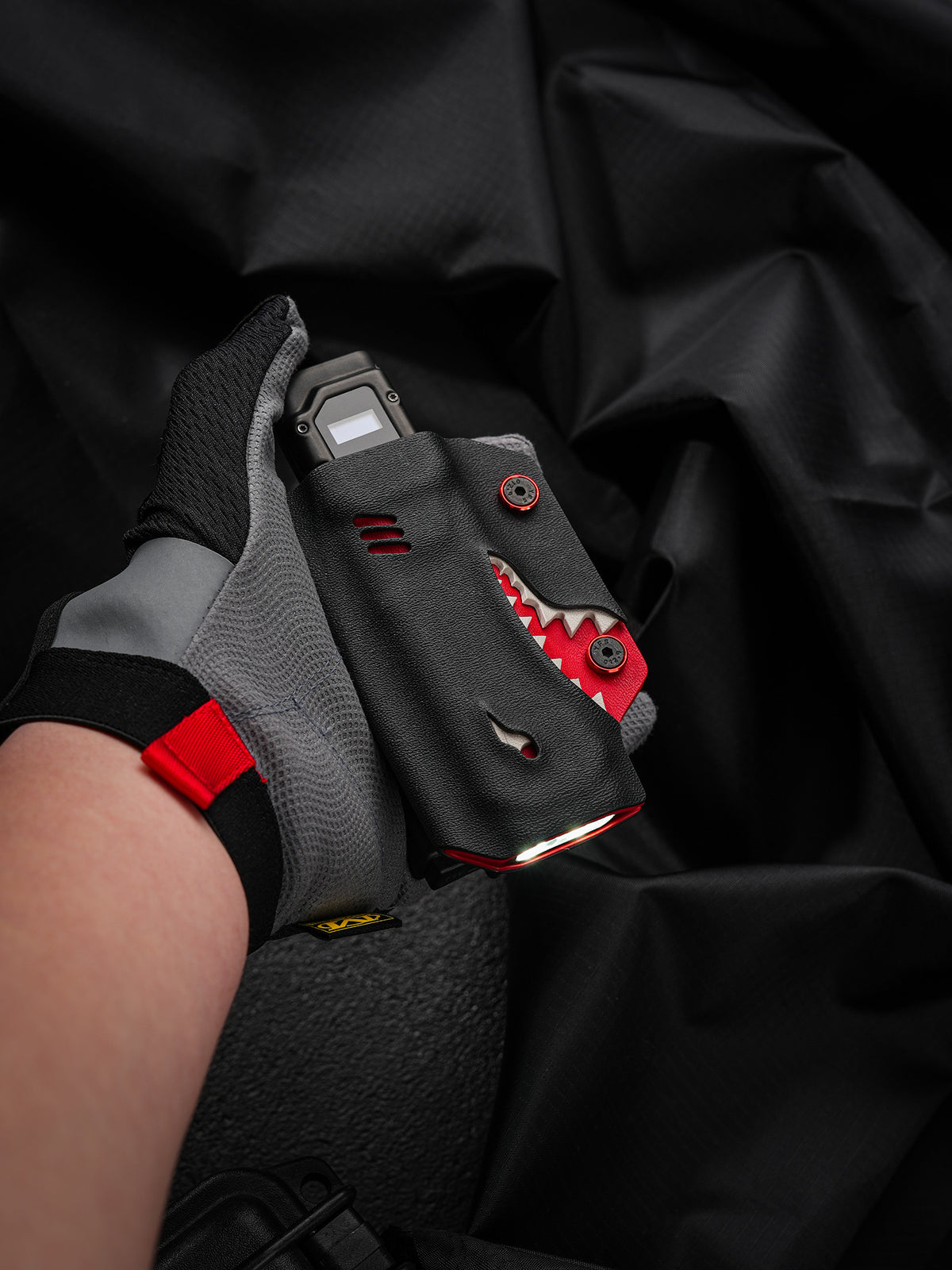 TACTICALGEEK TX9 flashlight sheath for Nitecore EDC27 shown handheld with the flashlight switched on.
