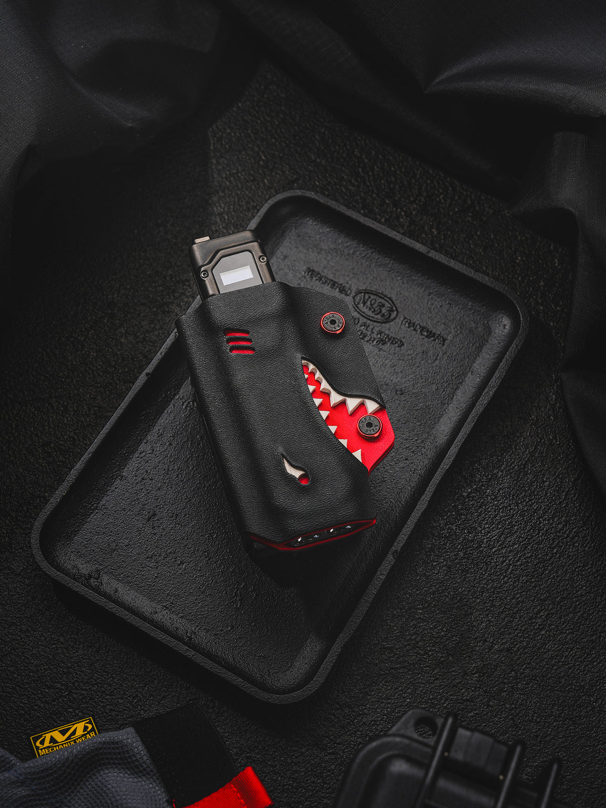 TACTICALGEEK TX9 flashlight sheath for Nitecore EDC27 displayed on a black tray with shark-style front detail.