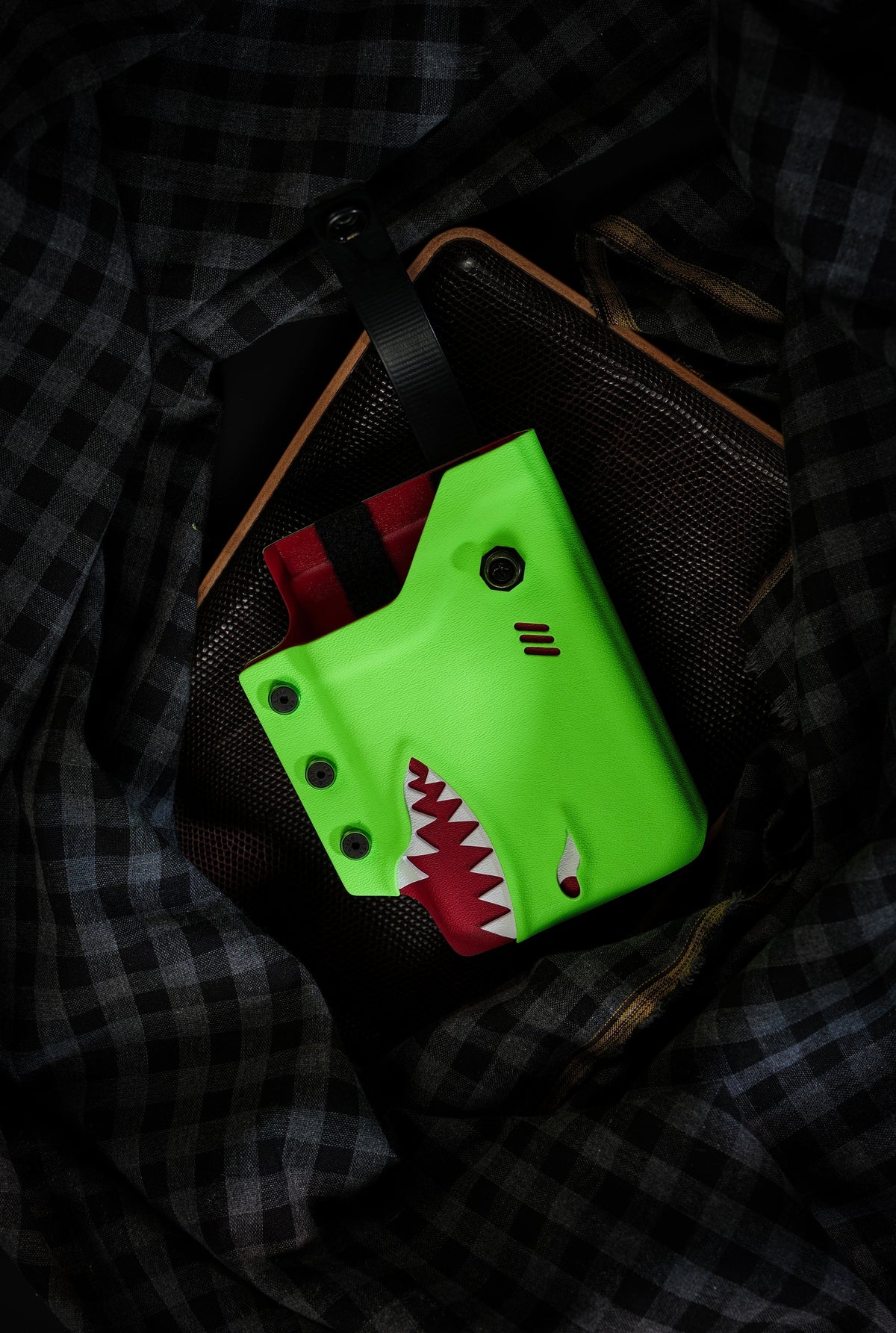 Close front view of the neon green TACTICALGEEK TG EDC KYDEX shark phone sheath holding an iPhone 17 Pro Max.