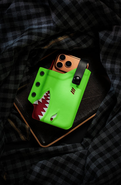 Top view of the neon green TACTICALGEEK TG EDC KYDEX shark phone sheath holding an iPhone 17 Pro Max on a tray.