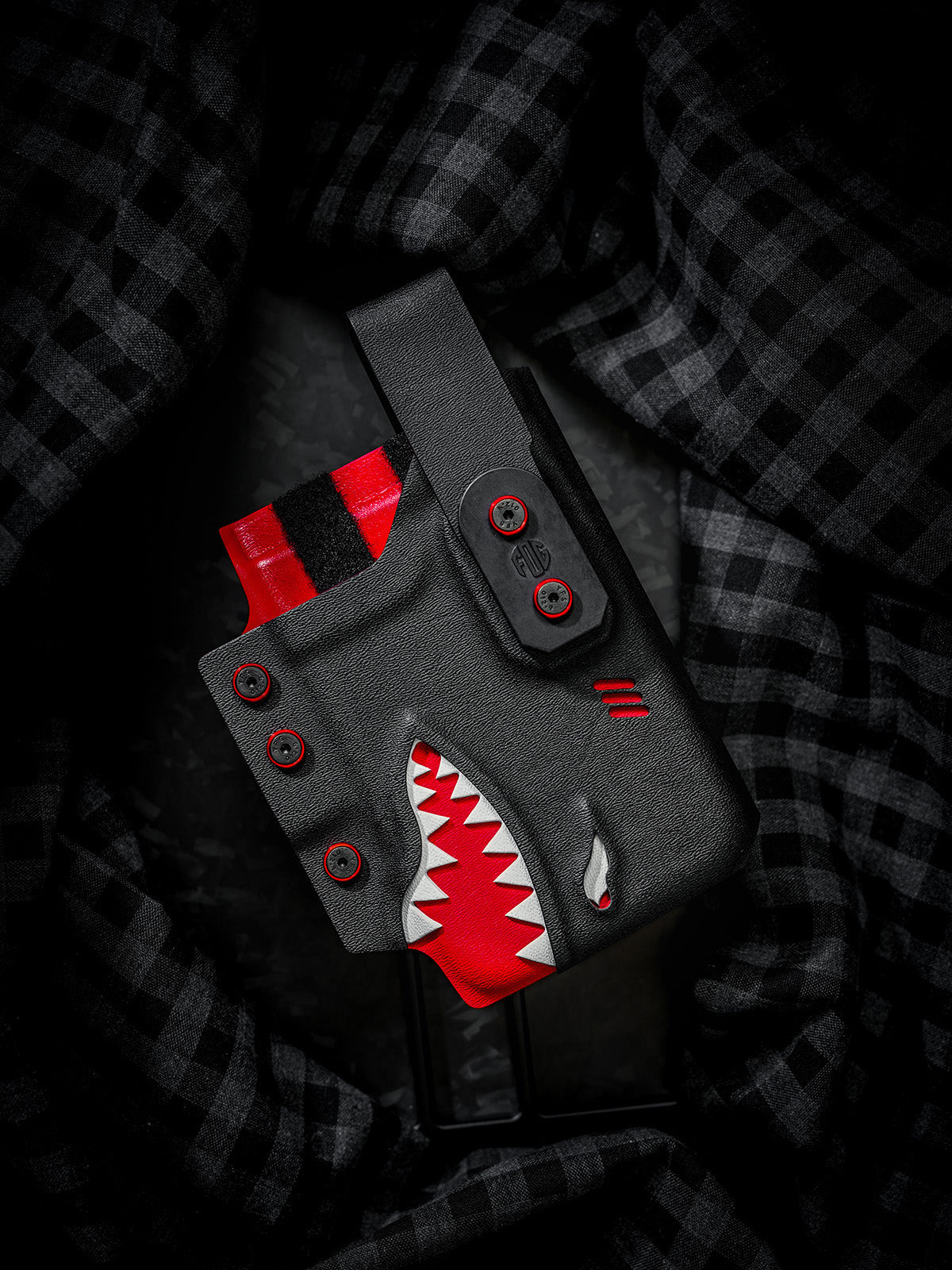 Angled front view of the black and red TACTICALGEEK TG EDC KYDEX shark phone sheath for iPhone 17 Pro and iPhone 17 Pro Max.