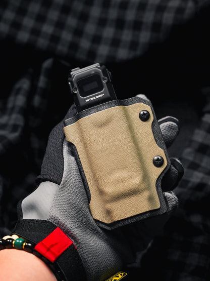 Gloved hand holding the sand-colored TX10 Flashlight Sheath with a Nitecore EDC29 flashlight visible at the top.