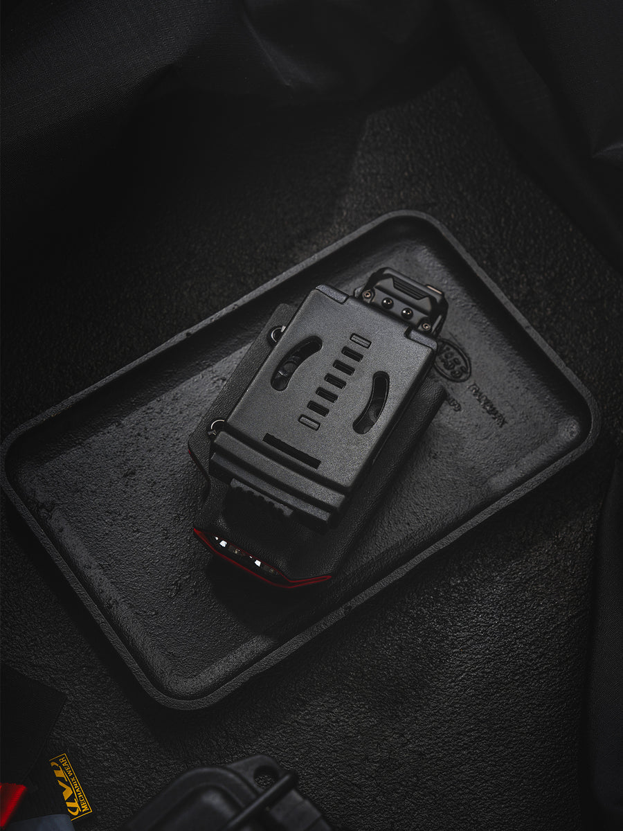 Rear view of the shark-style TX10 Flashlight Sheath showing the back clip while holding a Nitecore EDC29 flashlight.