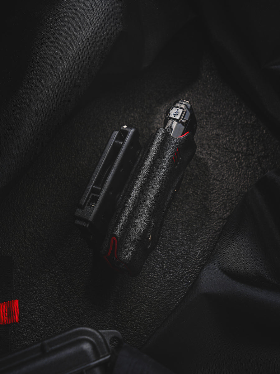 Side view of the shark-style TX10 Flashlight Sheath with a Nitecore EDC29 flashlight inserted and the belt clip shown beside it.