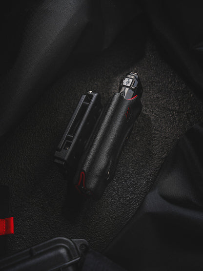 Side view of the shark-style TX10 Flashlight Sheath with a Nitecore EDC29 flashlight inserted and the belt clip shown beside it.