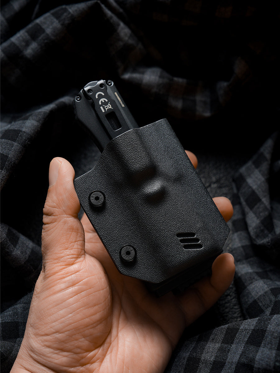 Hand holding the black TX17 flashlight sheath for Nitecore EDC17 with the flashlight inserted, showing the plain black exterior and compact carry design.