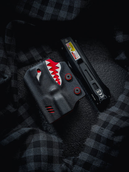 Flat lay of the TX17 shark-style flashlight sheath and Nitecore EDC17 flashlight placed separately on a dark textured fabric background.