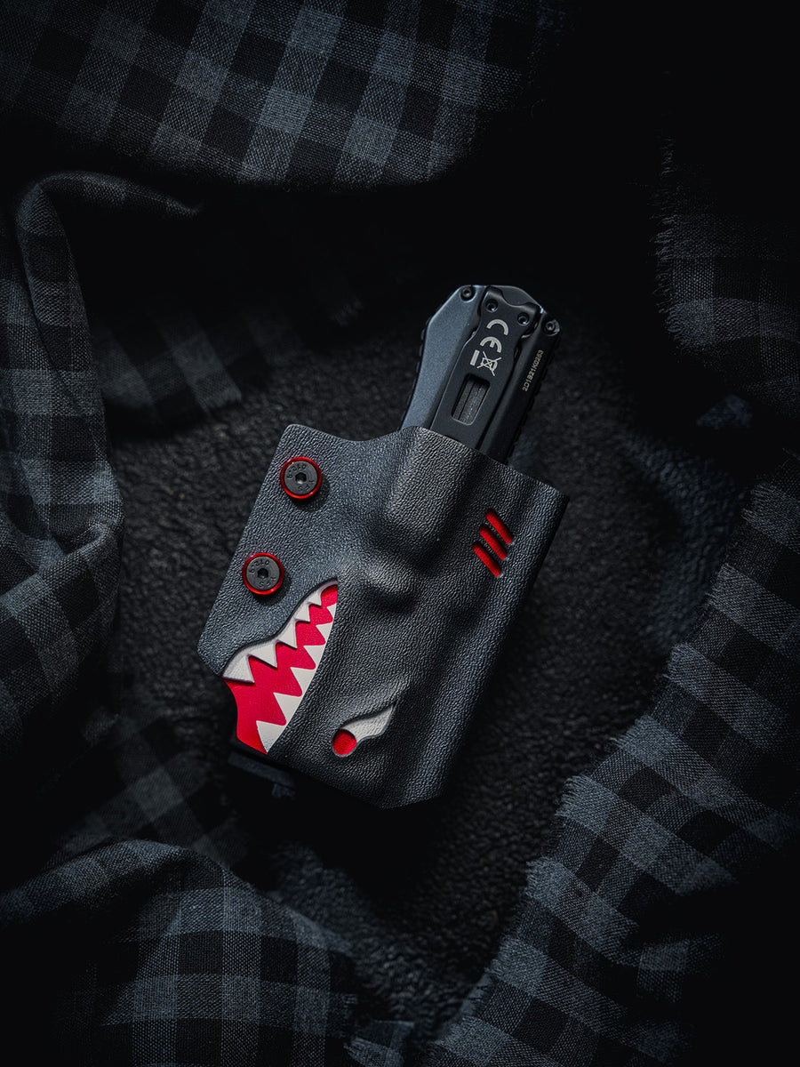 Front view of the TX17 shark-style flashlight sheath for Nitecore EDC17, shown with the flashlight inserted in the sheath on a dark plaid fabric background.