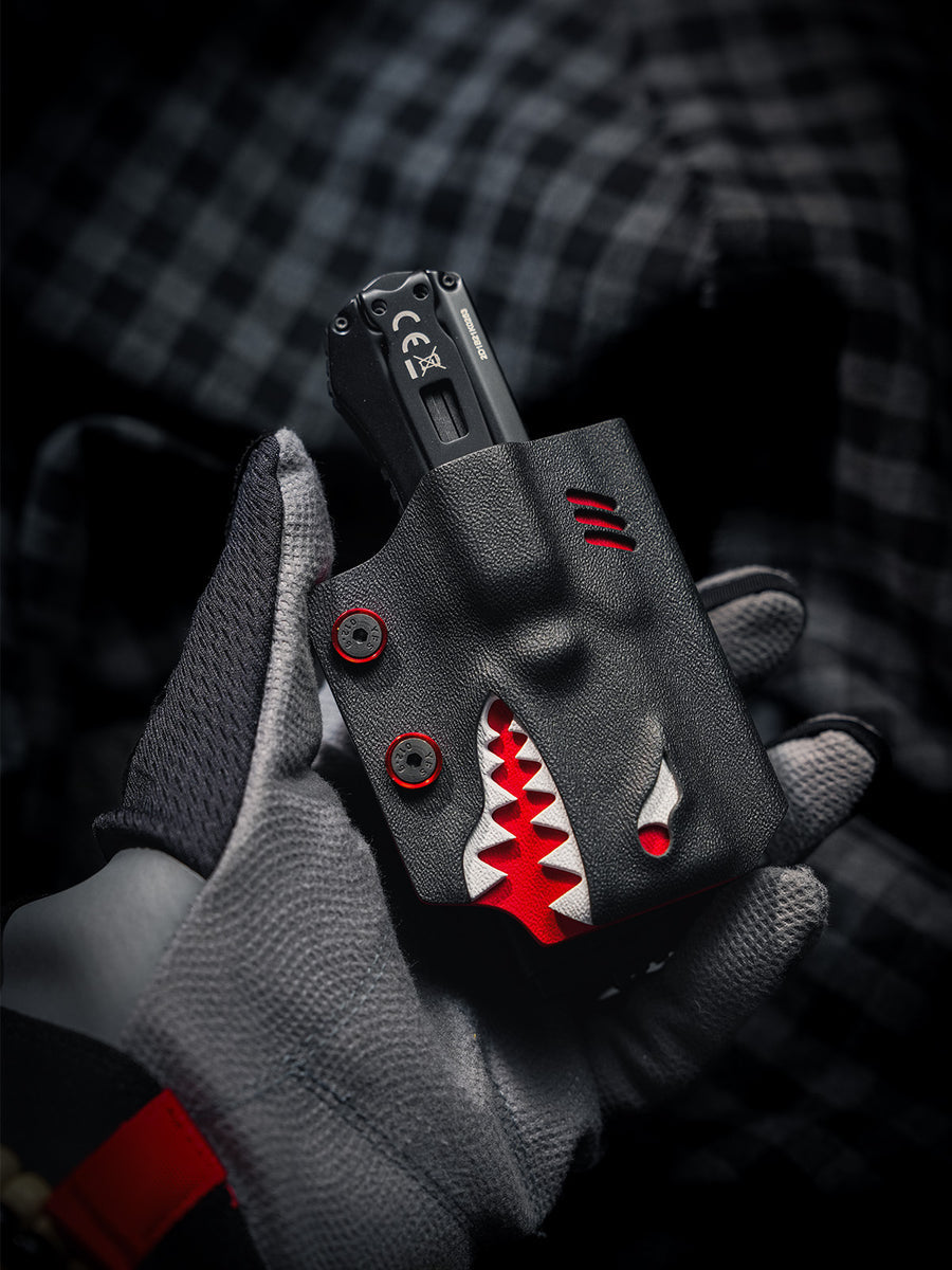 Gloved hand holding the TX17 shark-style flashlight sheath for Nitecore EDC17 with the flashlight inserted, highlighting the shark-inspired front design.